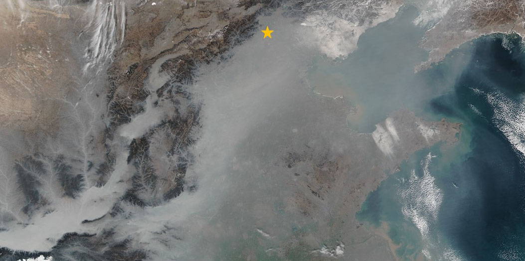 Vergr?sserte Ansicht: Grauer Smog bedeckt weite Teile Ostchinas im Januar 2017. Peking liegt nordwestlich der Bucht von Bohai (oranger Stern). (Bild: Nasa Earth Observatory)