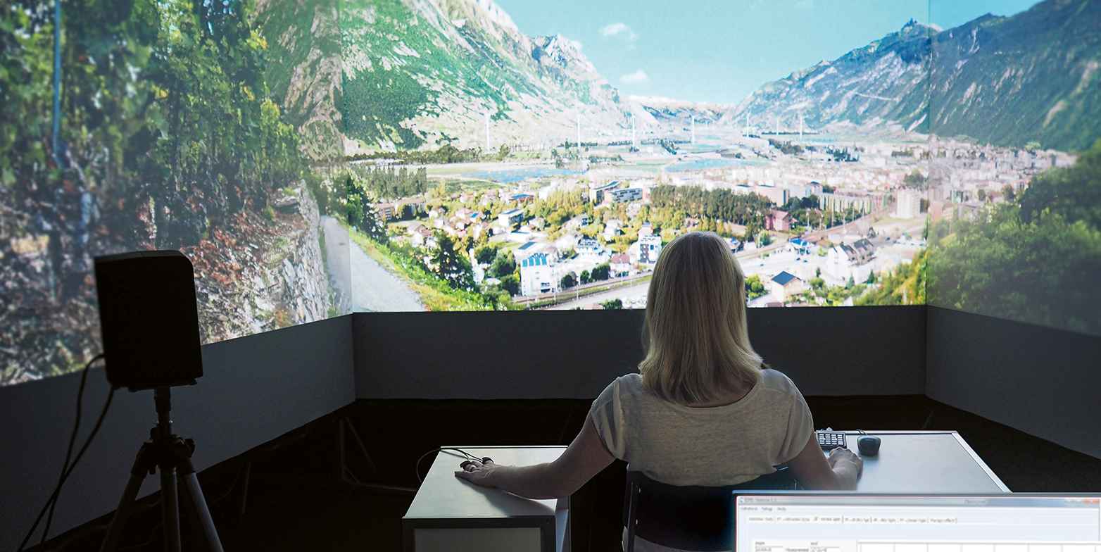 Frau sitzt in einem Virtual Reality Labor mit Landschaftsbildern