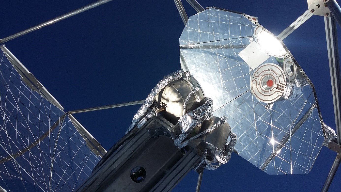 Der der Sonne nachgeführte Parabolreflektor liefert konzentriertes Sonnenlicht an einen Solarreaktor (über den Sekundärreflektor gesehen), der aus der Luft extrahiertes CO<sub>2</sub> und Wasser in ein Synthesegasgemisch umwandelt, das wiederum zu Drop-in-Treibstoffen wie Kerosin verarbeitet wird (Bild: ETH Zürich)