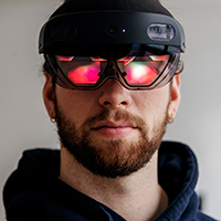 Lukas Roder trägt eine AR-Brille und bedient das virtuelle Programm mit dem Finger