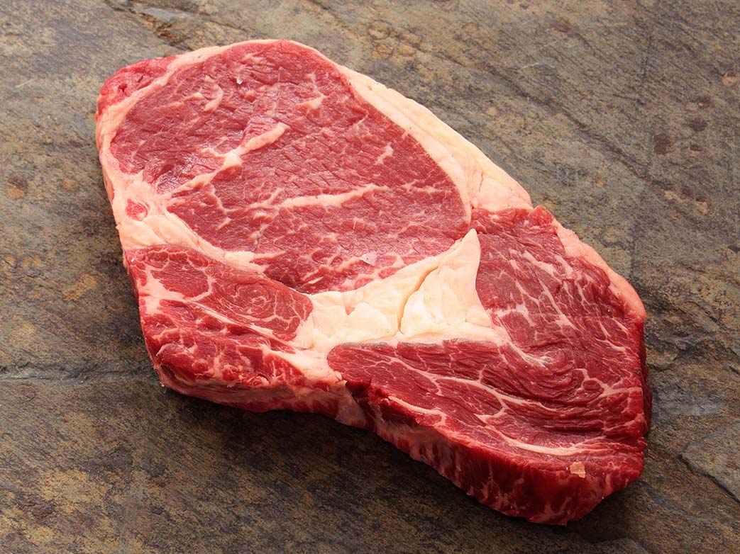 Ribeye-Steak auf einer Holzplatte