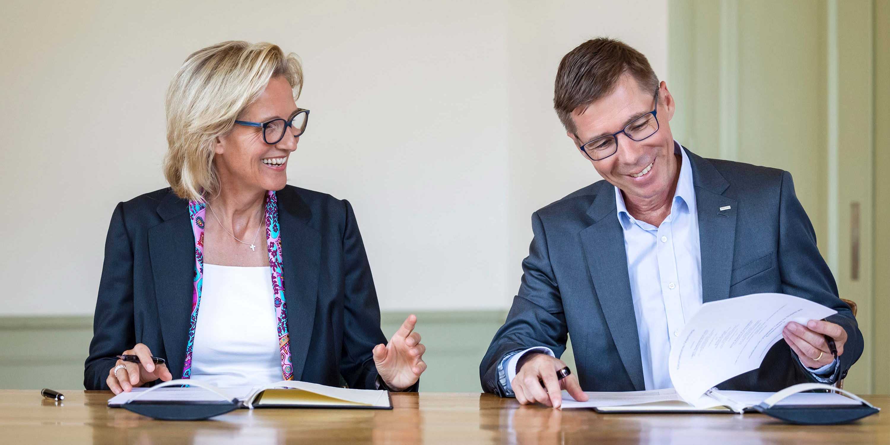 Sabine Keller-Busse und Joël Mesot unterzeichnen lächelnd den Vertrag