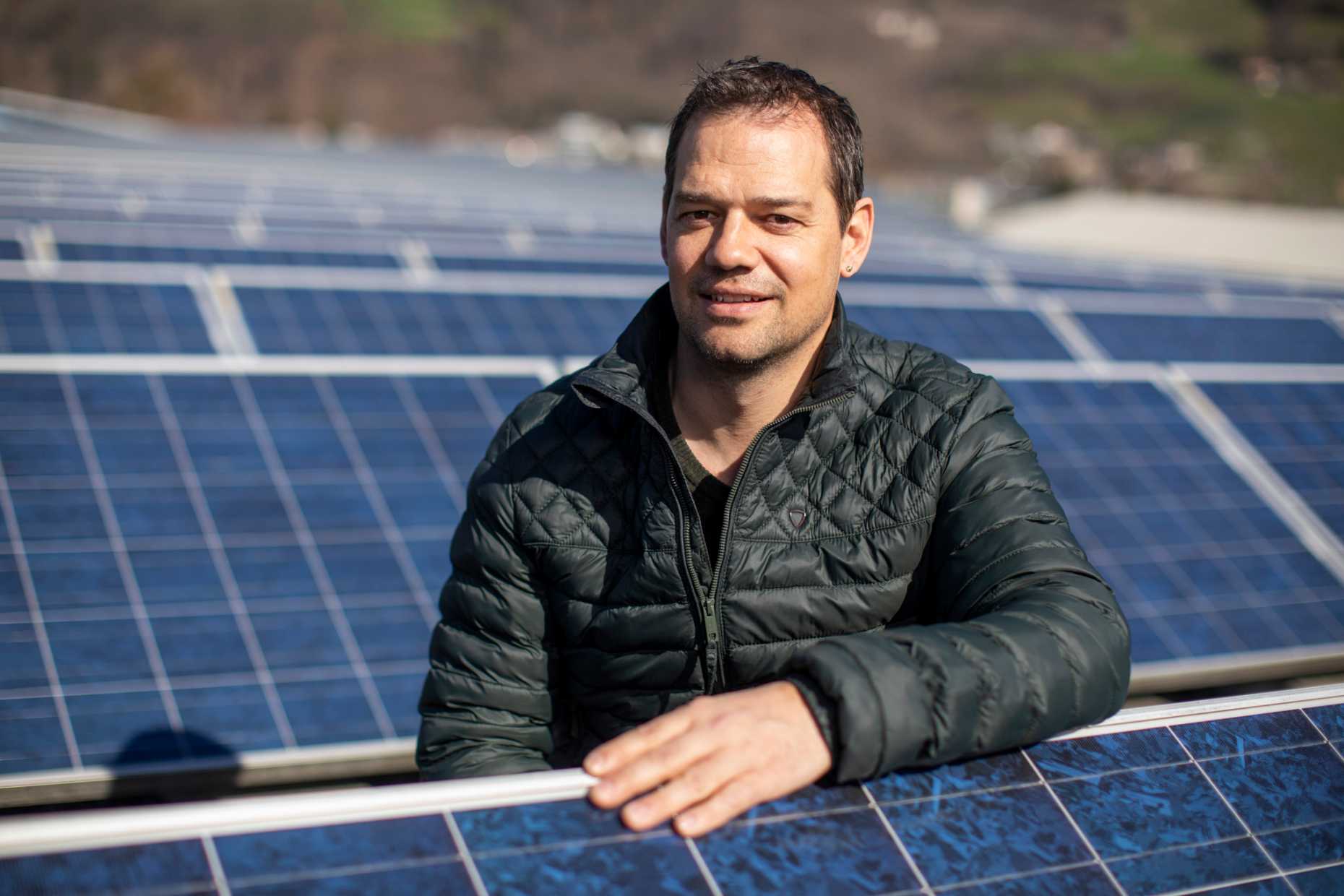 Christian Dürr auf einem Dach mit Solarpanelen