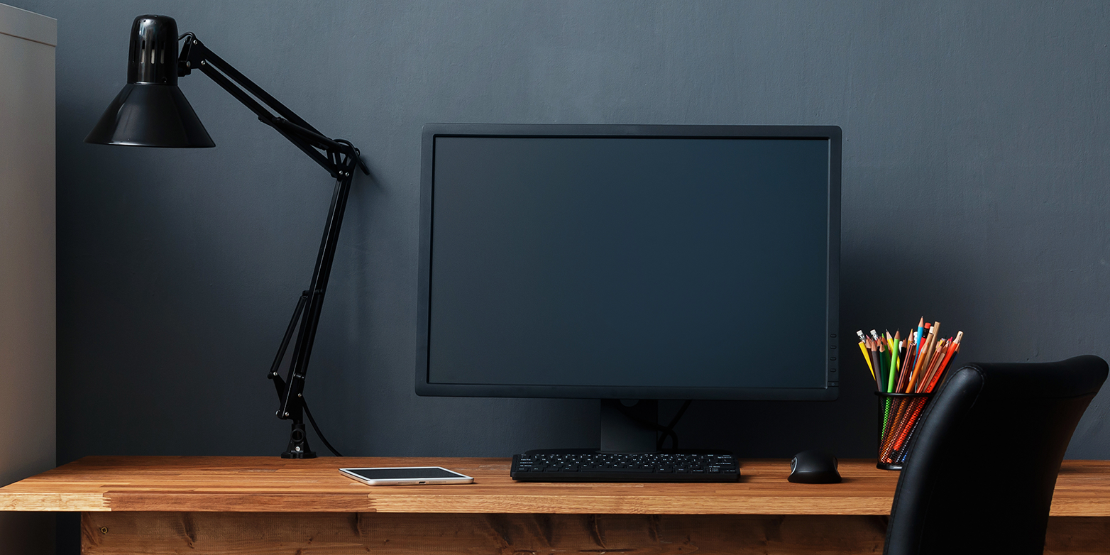 A monitor, mouse, keyboard and tablet on a desk